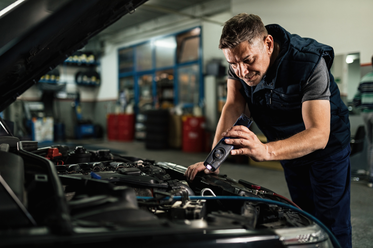 Photo of mechanic looking at engine compartment