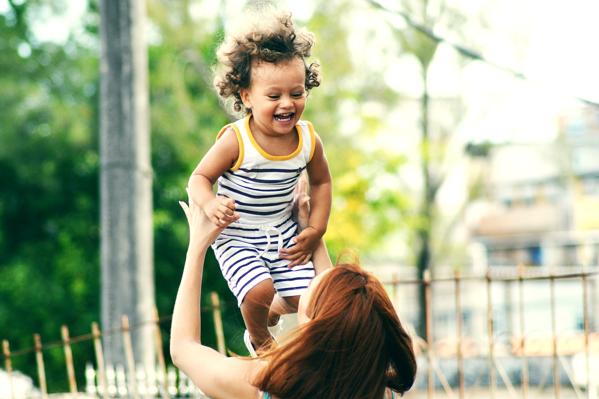 mom throwing child in the air